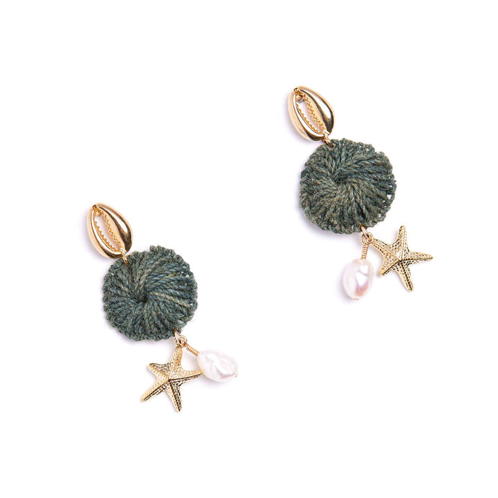 Pair of earrings with green pom-poms, starfish charms, and pearls on a white background