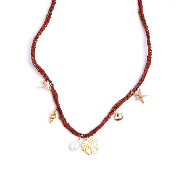 Red cord necklace with gold charms on a white background