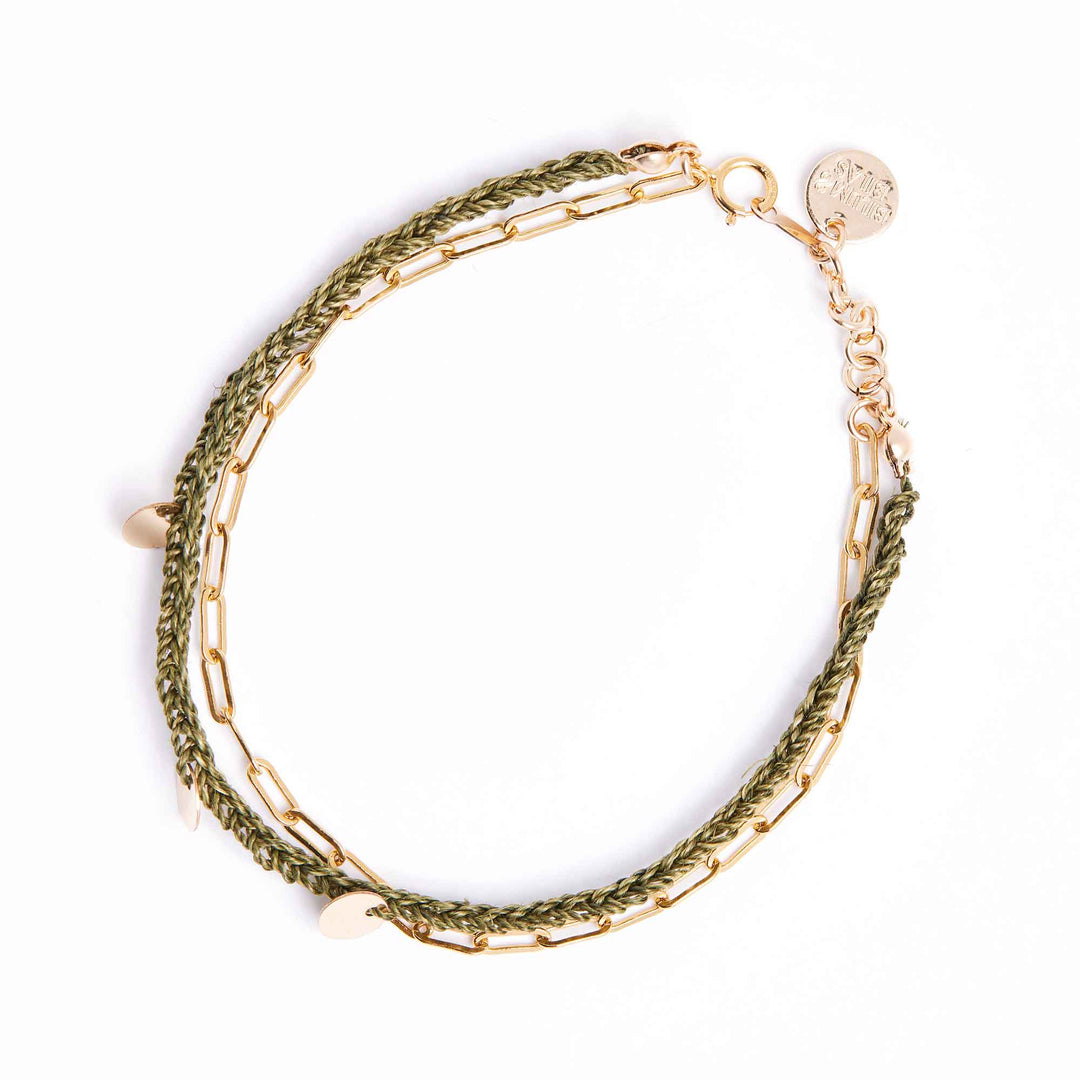 Gold and green braided bracelet on a white background