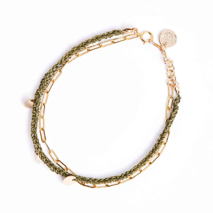 Gold and green braided bracelet on a white background