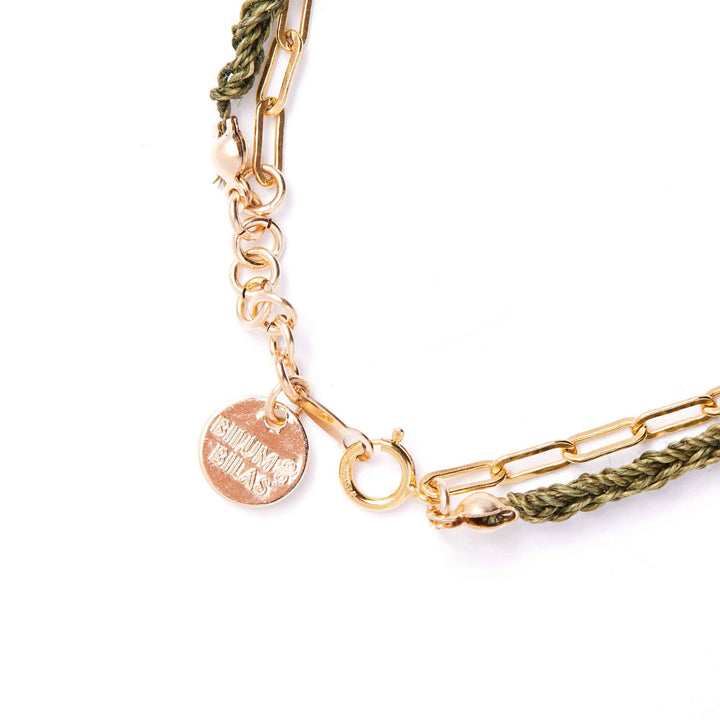 Gold and green braided bracelet on a white background