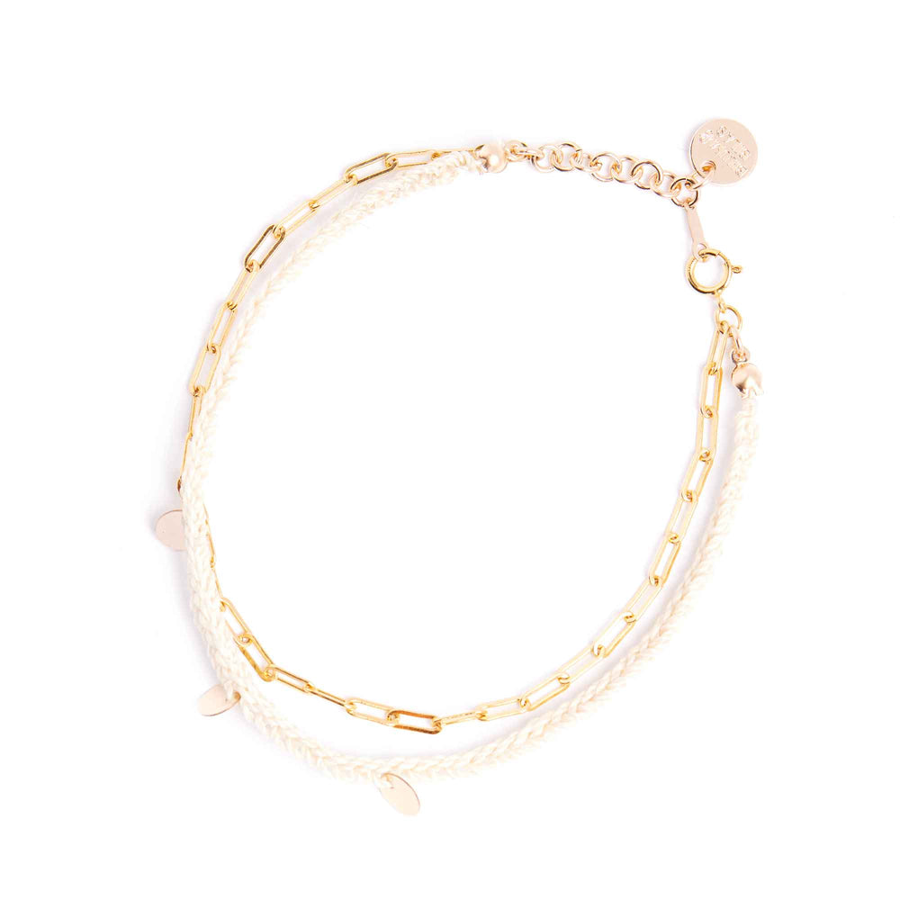 Gold chain bracelet with clear beads on a white background