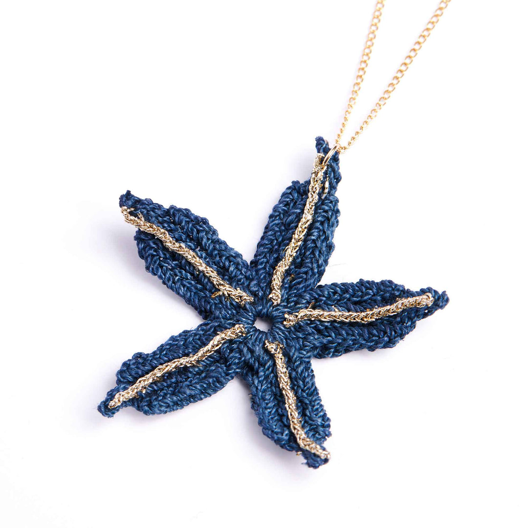 Blue starfish-shaped pendant on a gold chain against a white background