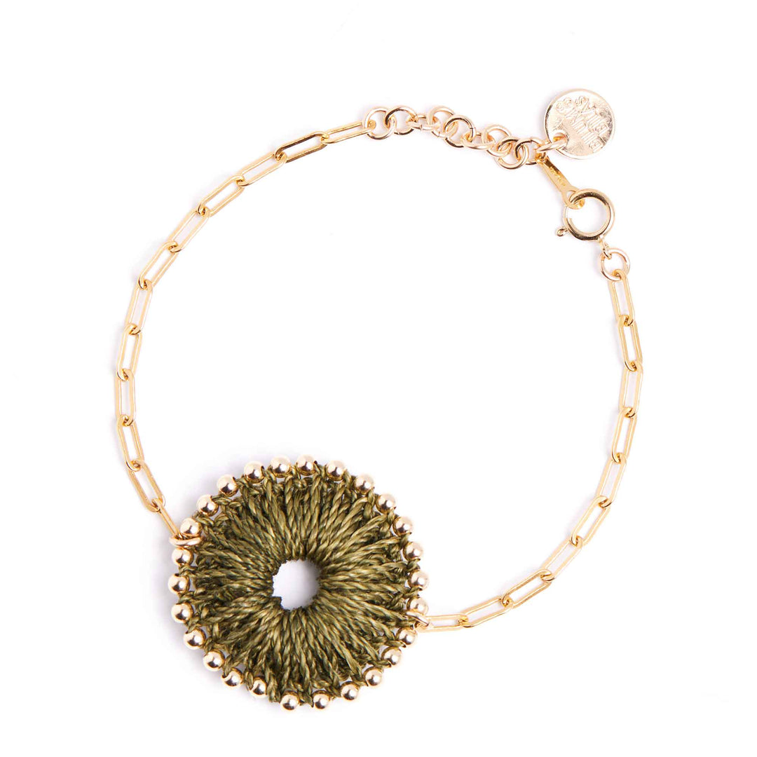 Gold bracelet with a textured green circular charm on a white background