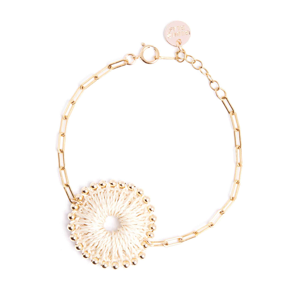 Gold bracelet with a decorative clasp on a white background