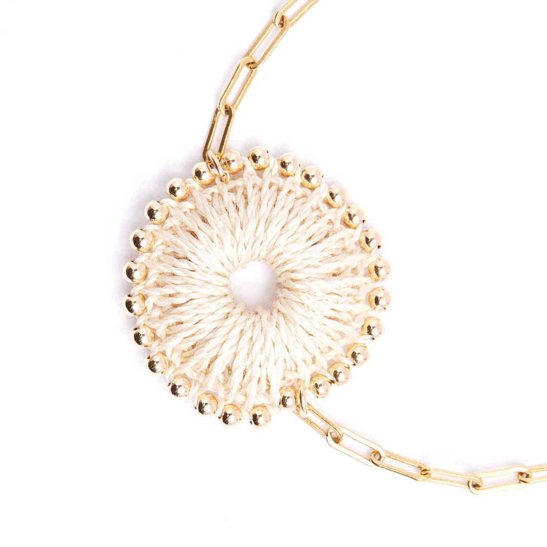 Gold bracelet with a central pearl on a white background