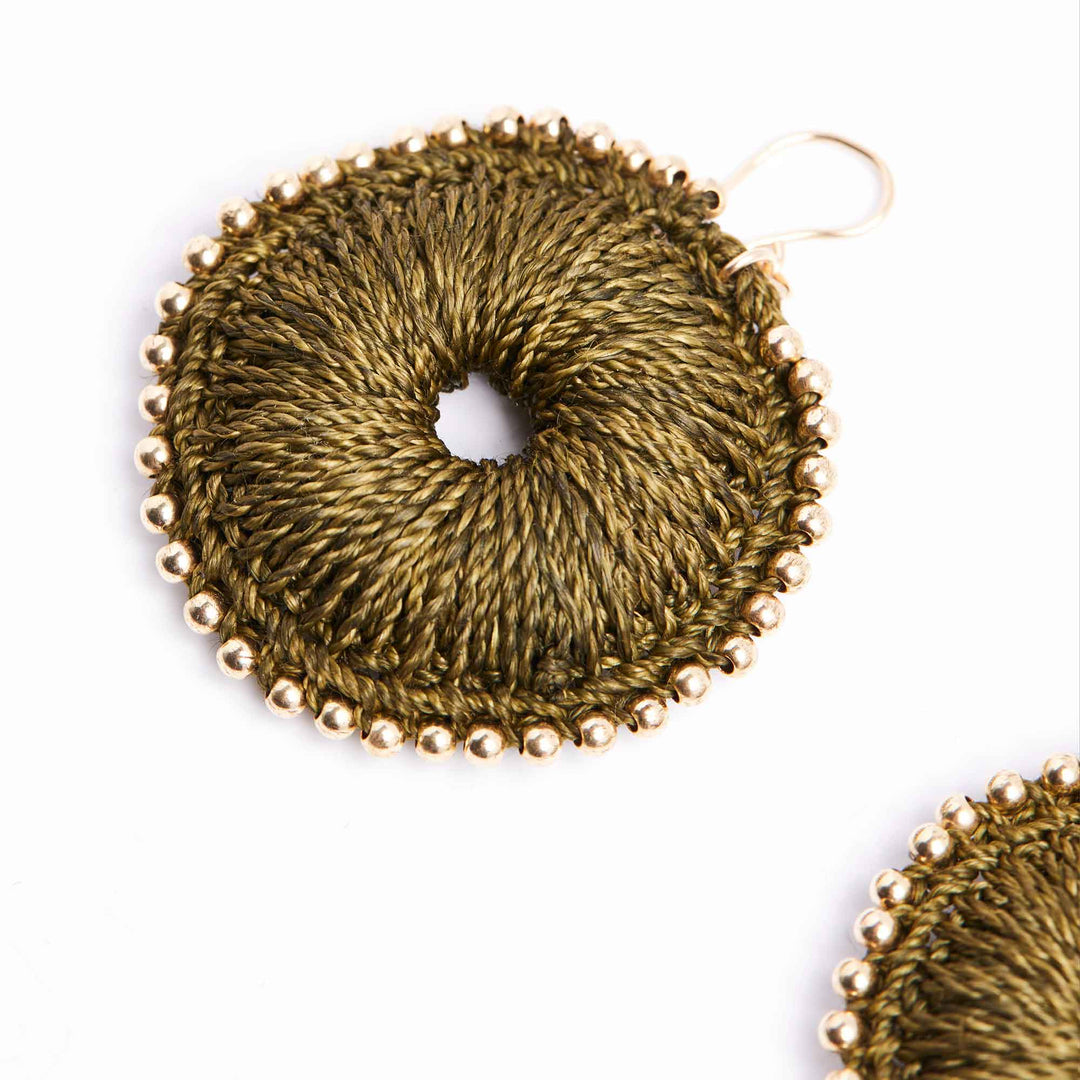 Gold circular earrings with textured design on a white background