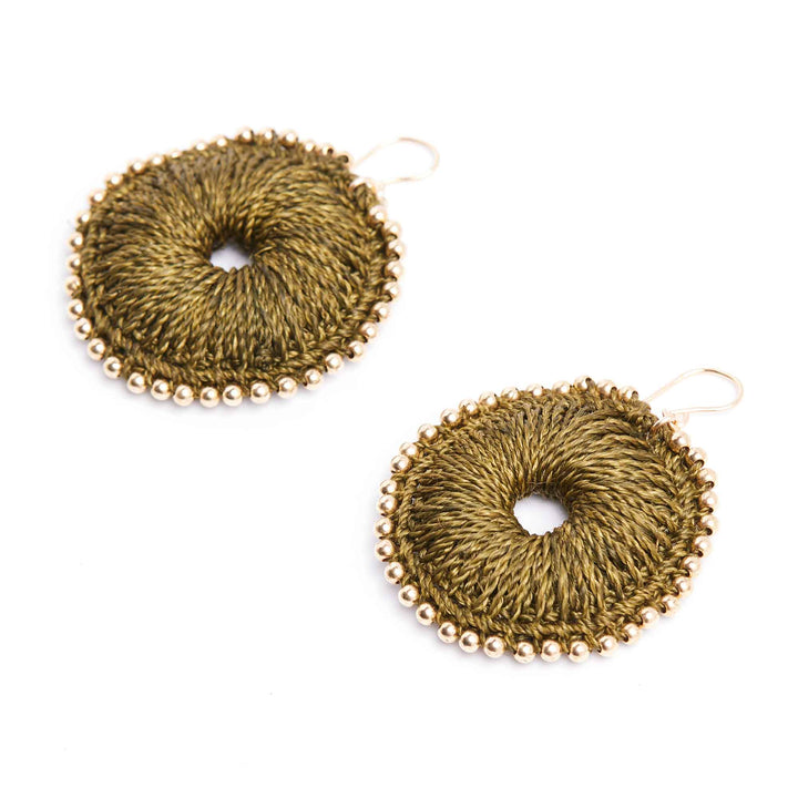 Pair of gold circular earrings with bead detailing on a white background