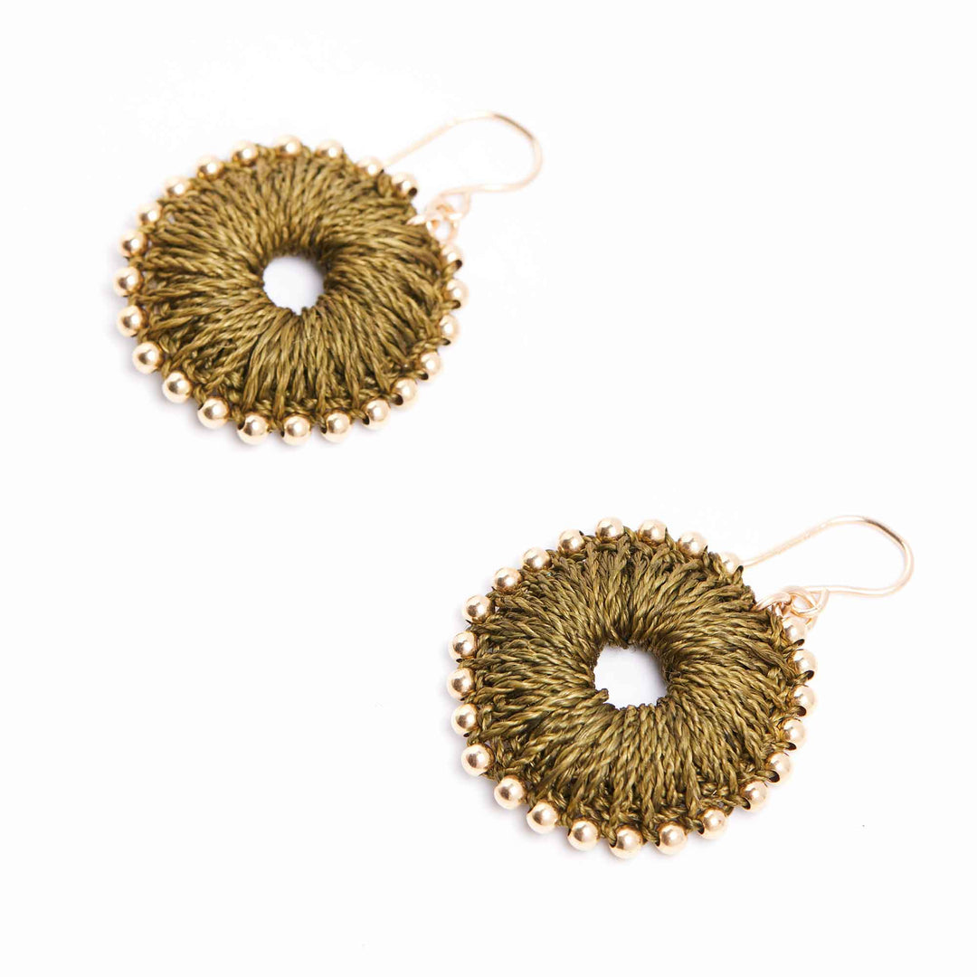 Pair of gold circular earrings with bead detailing on a white background