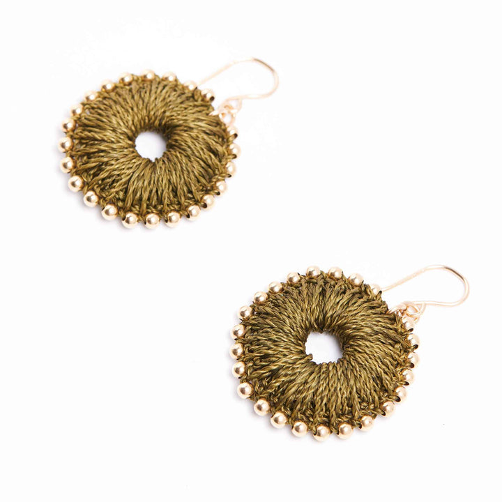 Pair of gold circular earrings with bead detailing on a white background
