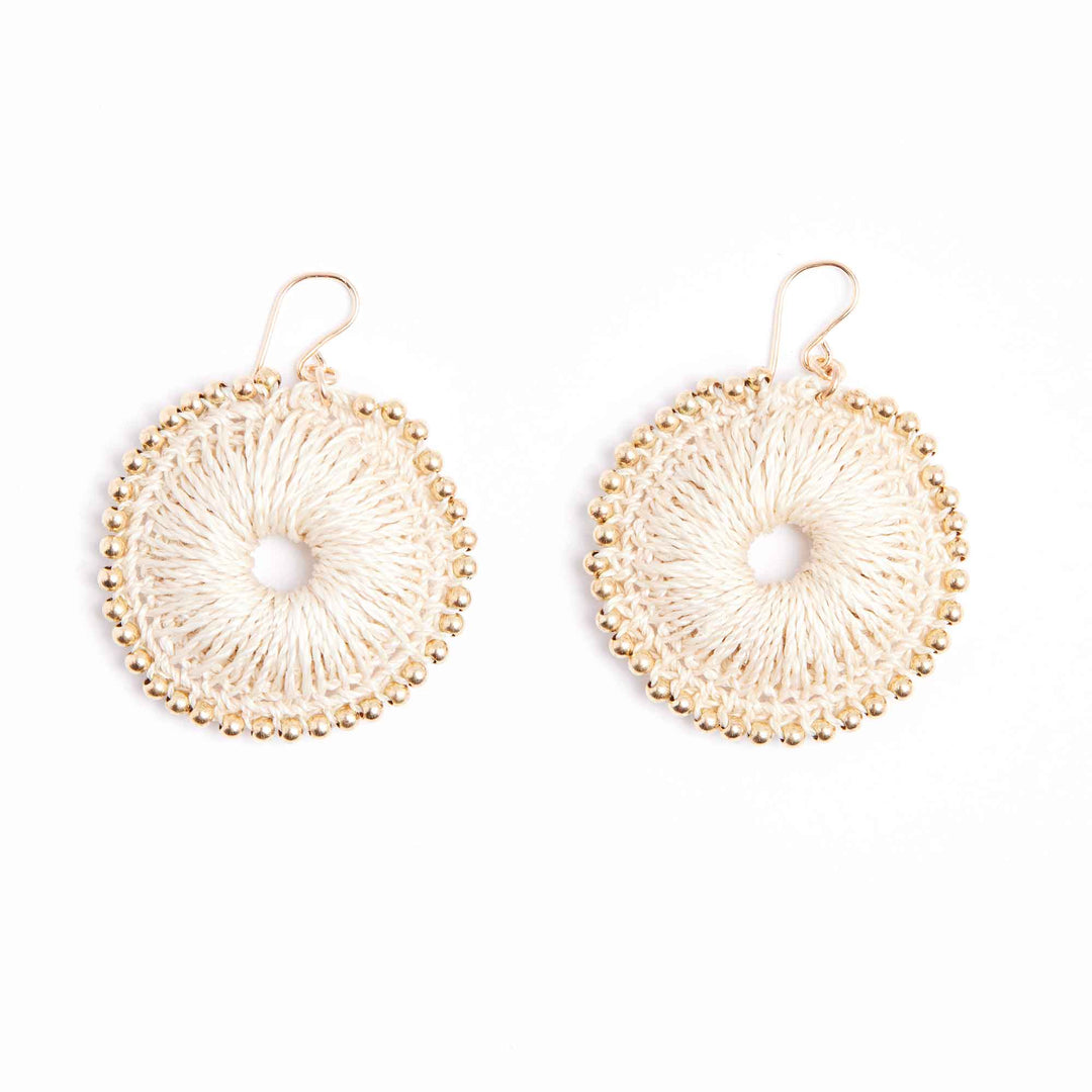 Pair of gold circular earrings with a central pearl on a white background