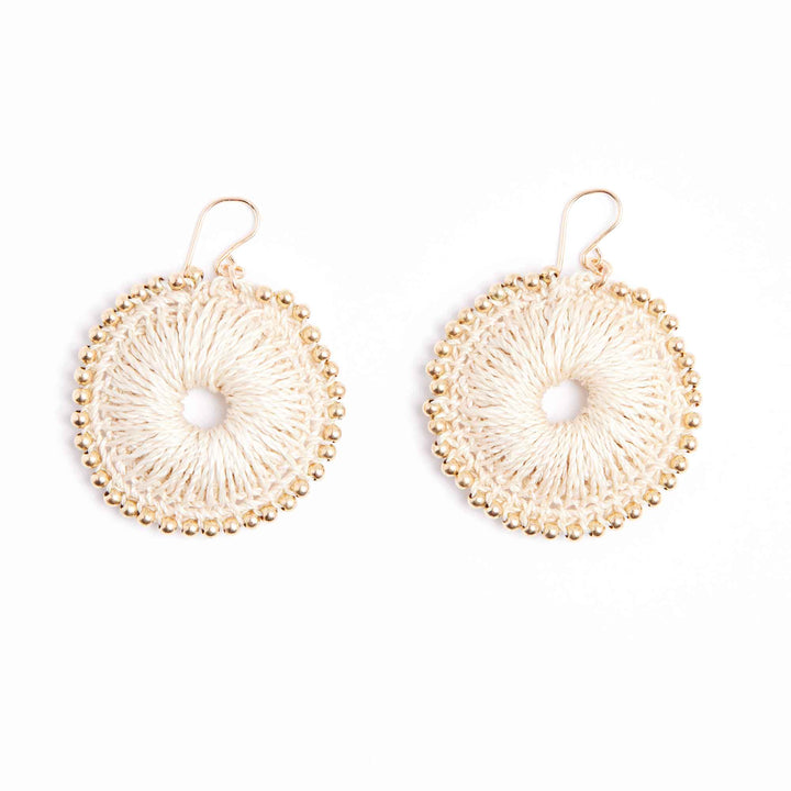 Pair of gold circular earrings with a central pearl on a white background