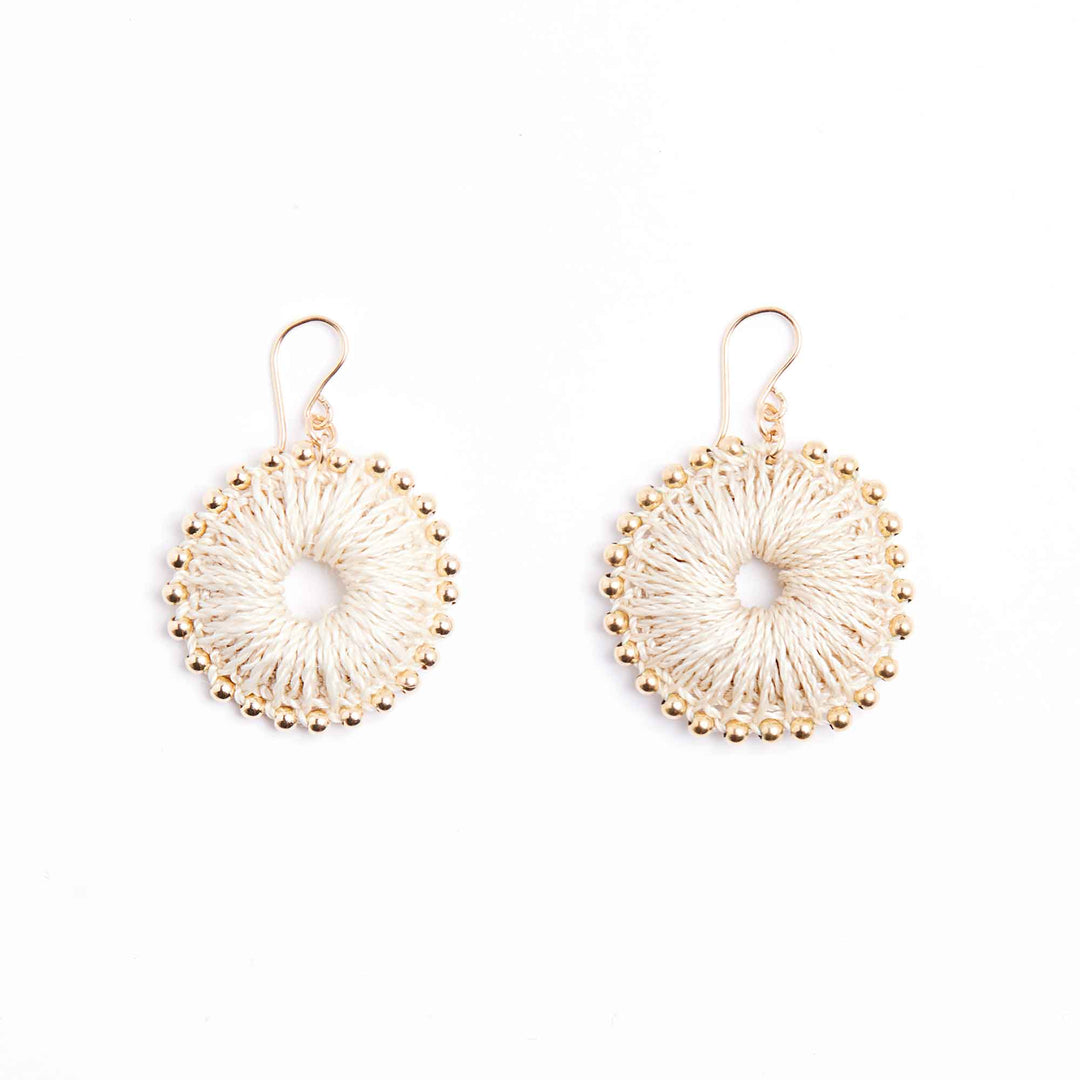 Pair of gold and white circular earrings on a white background