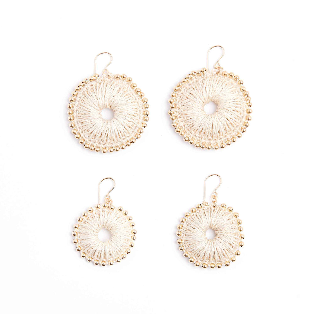 Set of four gold circular earrings on a white background