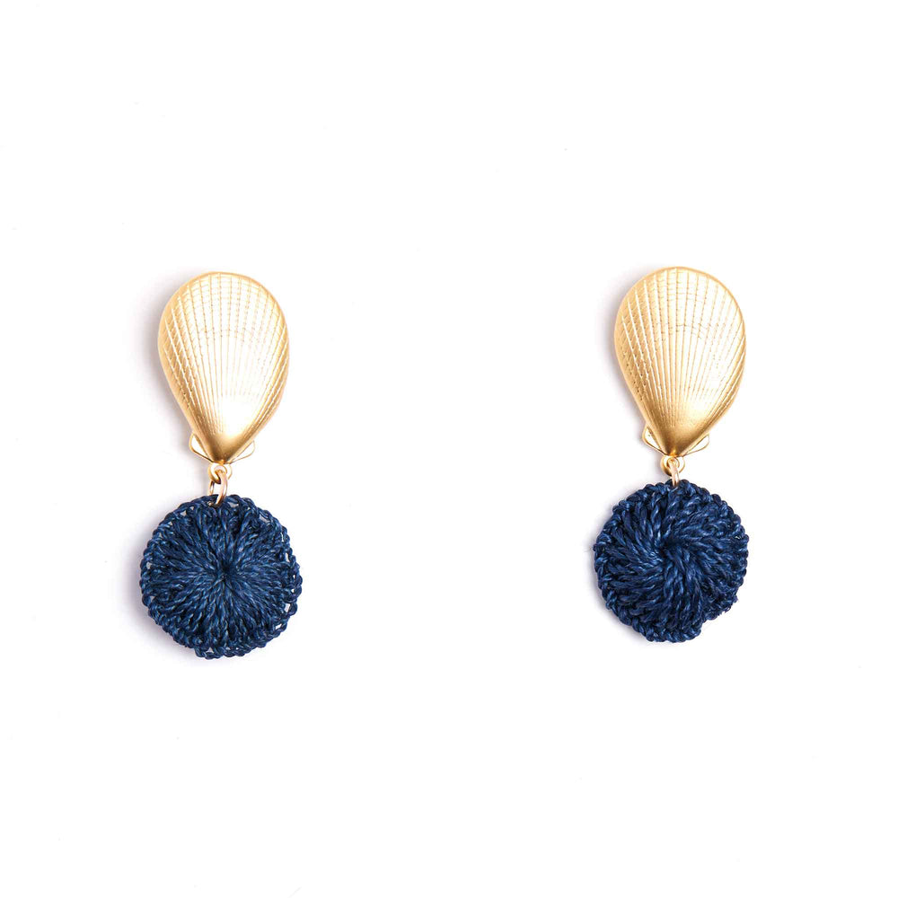 Gold earrings with blue pom-pom drops on a white background