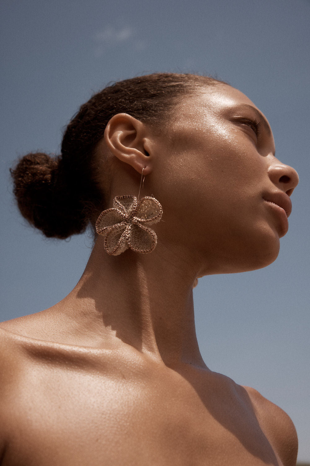 Model wearing bilum and bilas frangipani handwoven flower statement earrings
