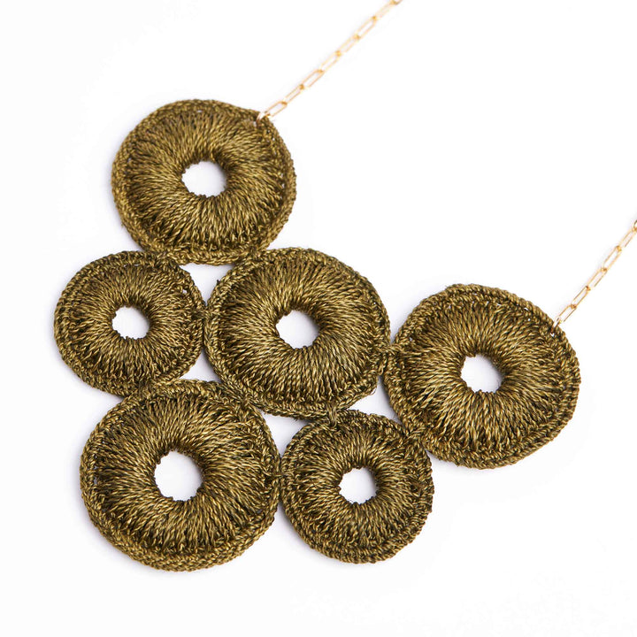 Gold-colored crochet donut rings on a white background