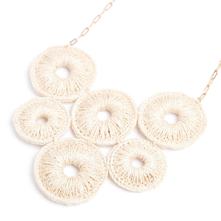 Necklace with beige crocheted circular pendants on a white background