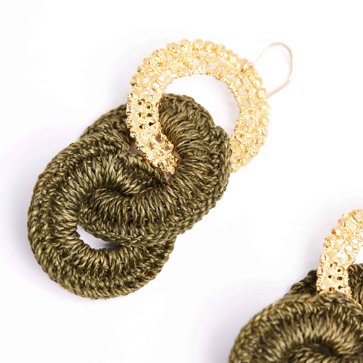 Pair of gold and green knitted earrings on a white background