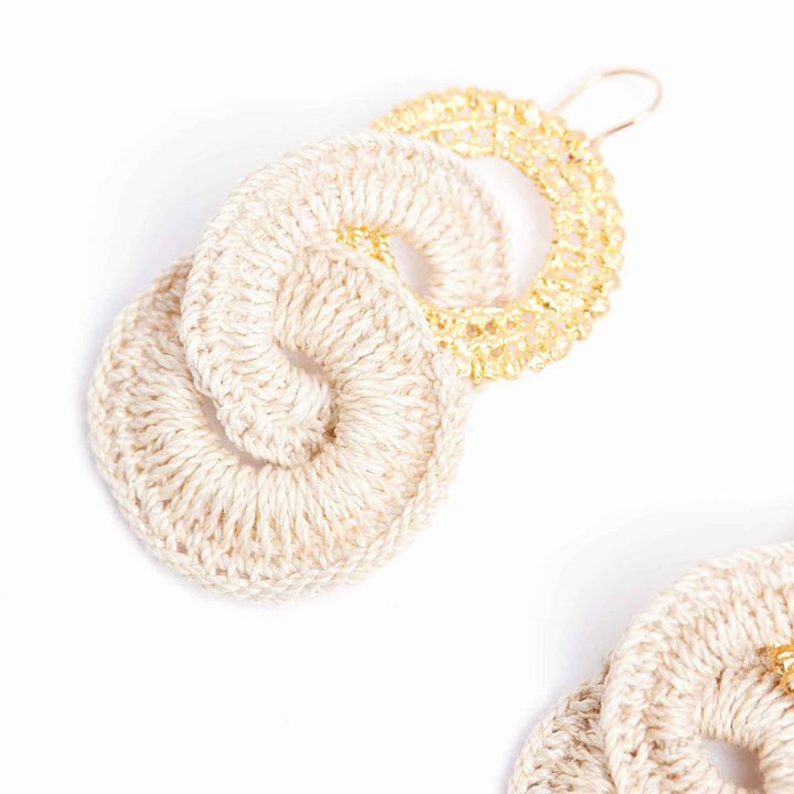 Three beige crocheted scrunchies on a white background