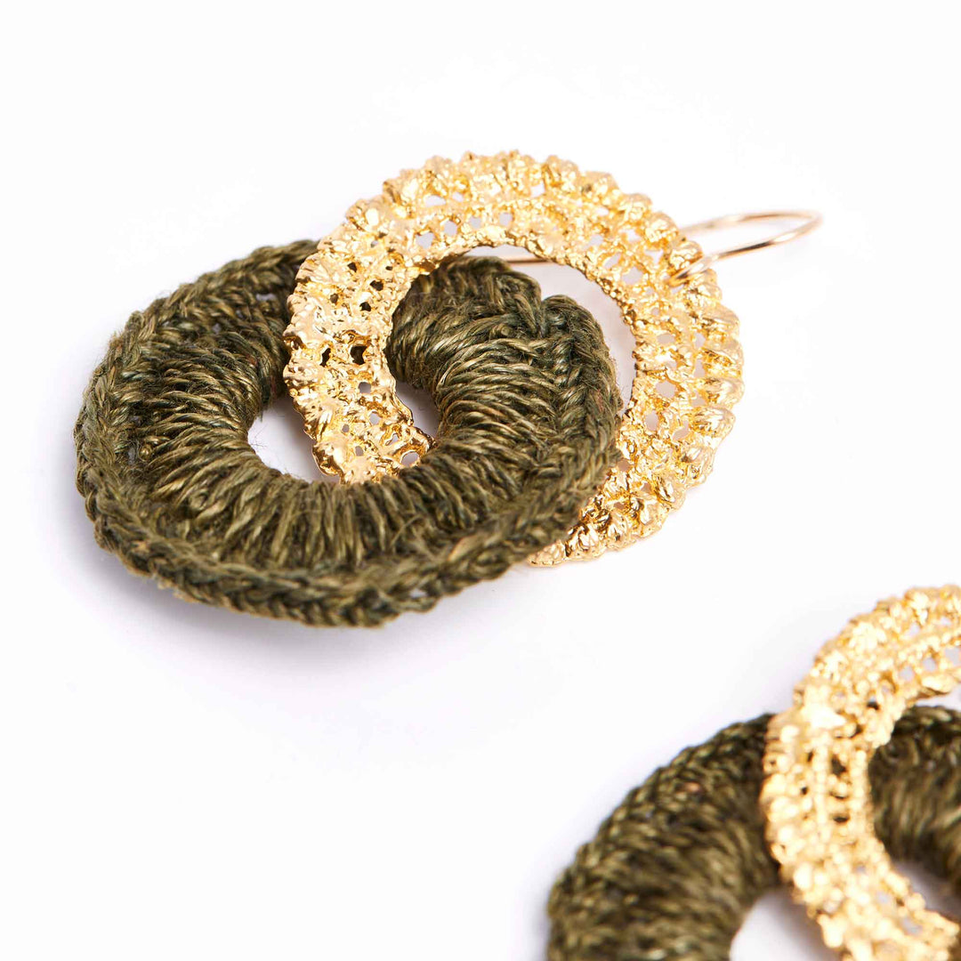 Gold and green hoop earrings on a white background