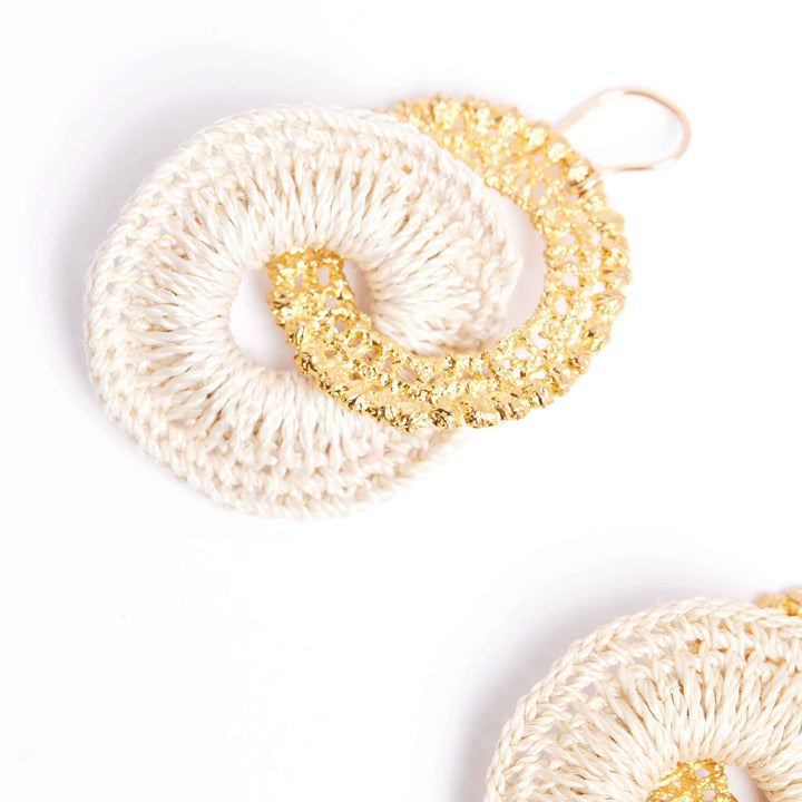 Two crocheted scrubbies, one white and one gold, on a light gray background.
