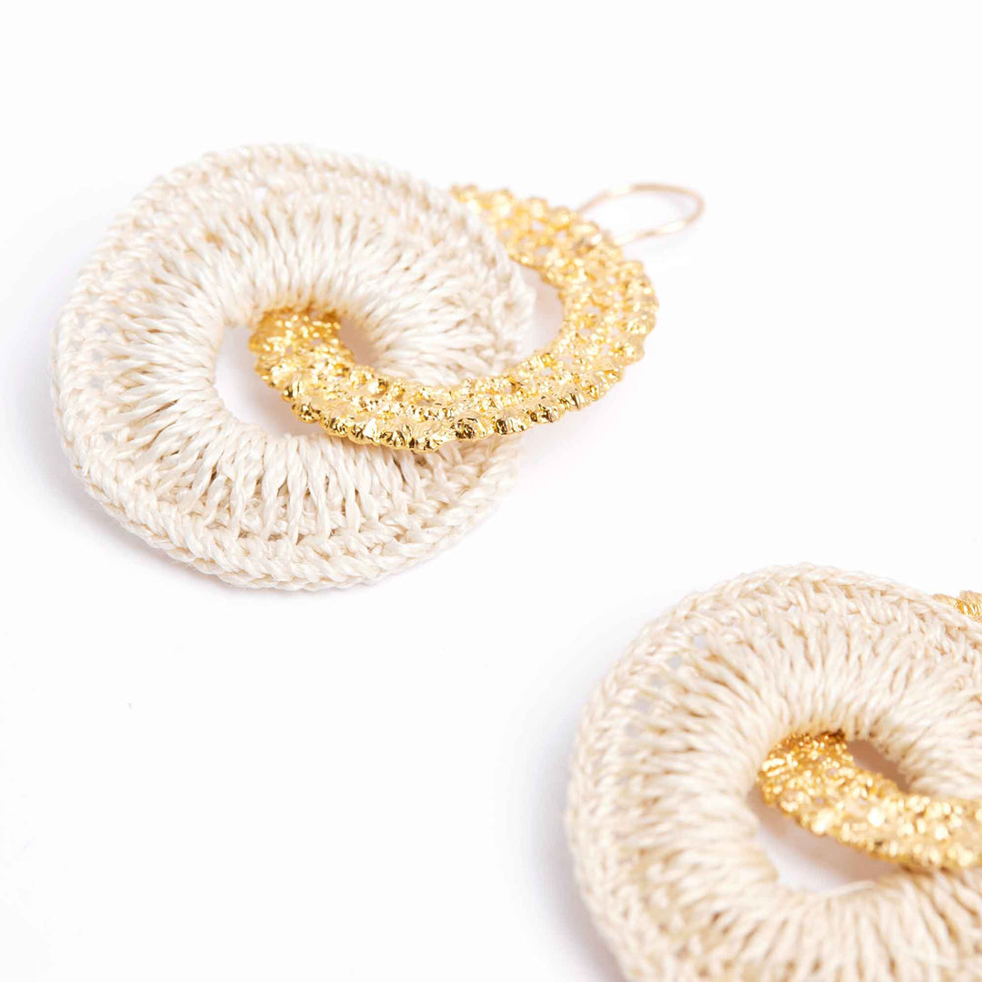 Pair of earrings with white and gold circular designs on a white background