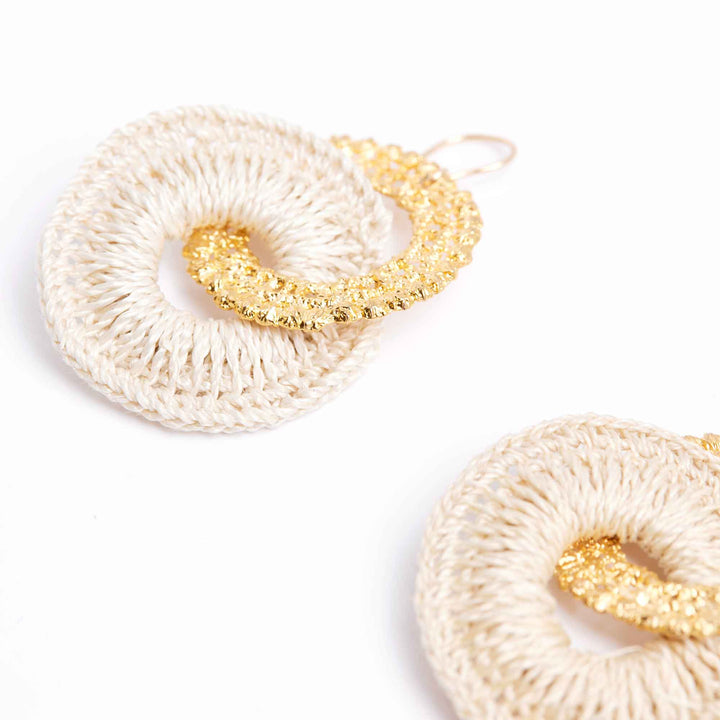 Pair of earrings with white and gold circular designs on a white background