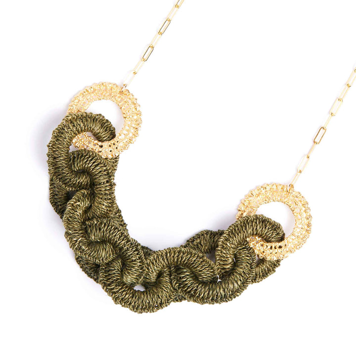 Necklace with green crocheted design and gold circular elements on a white background