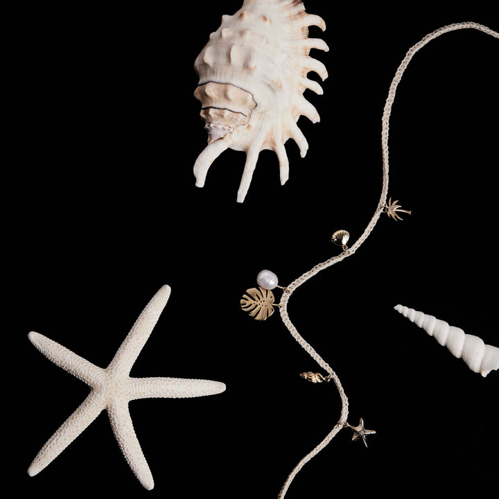Jewelry with pearls and shells on a black background