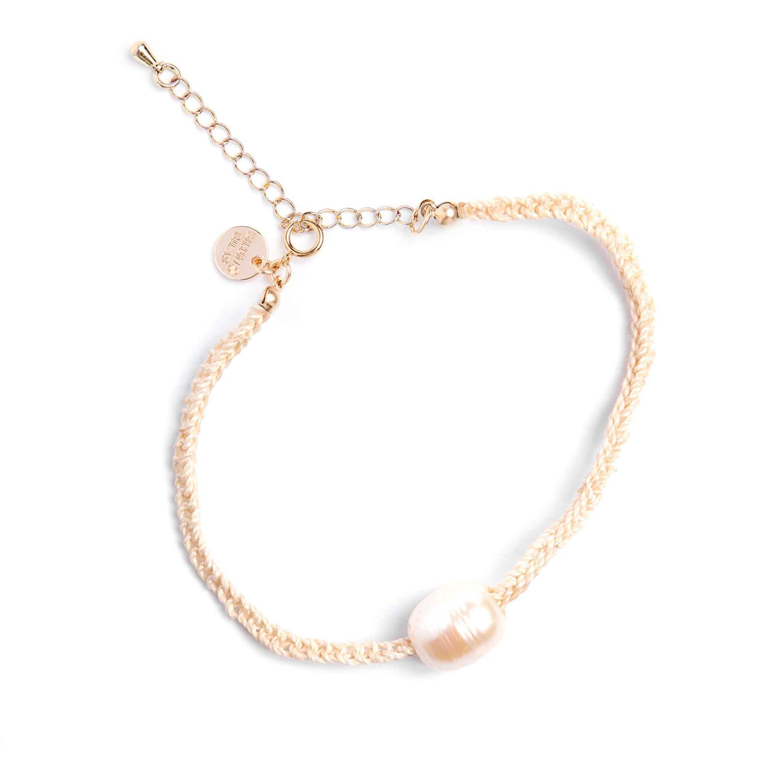 Gold bracelet with a pearl on a white background