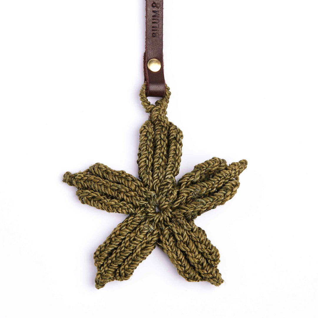 Crocheted leaf-shaped keychain with a leather strap on a white background