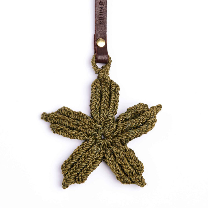 Crocheted leaf-shaped keychain with a leather strap on a white background