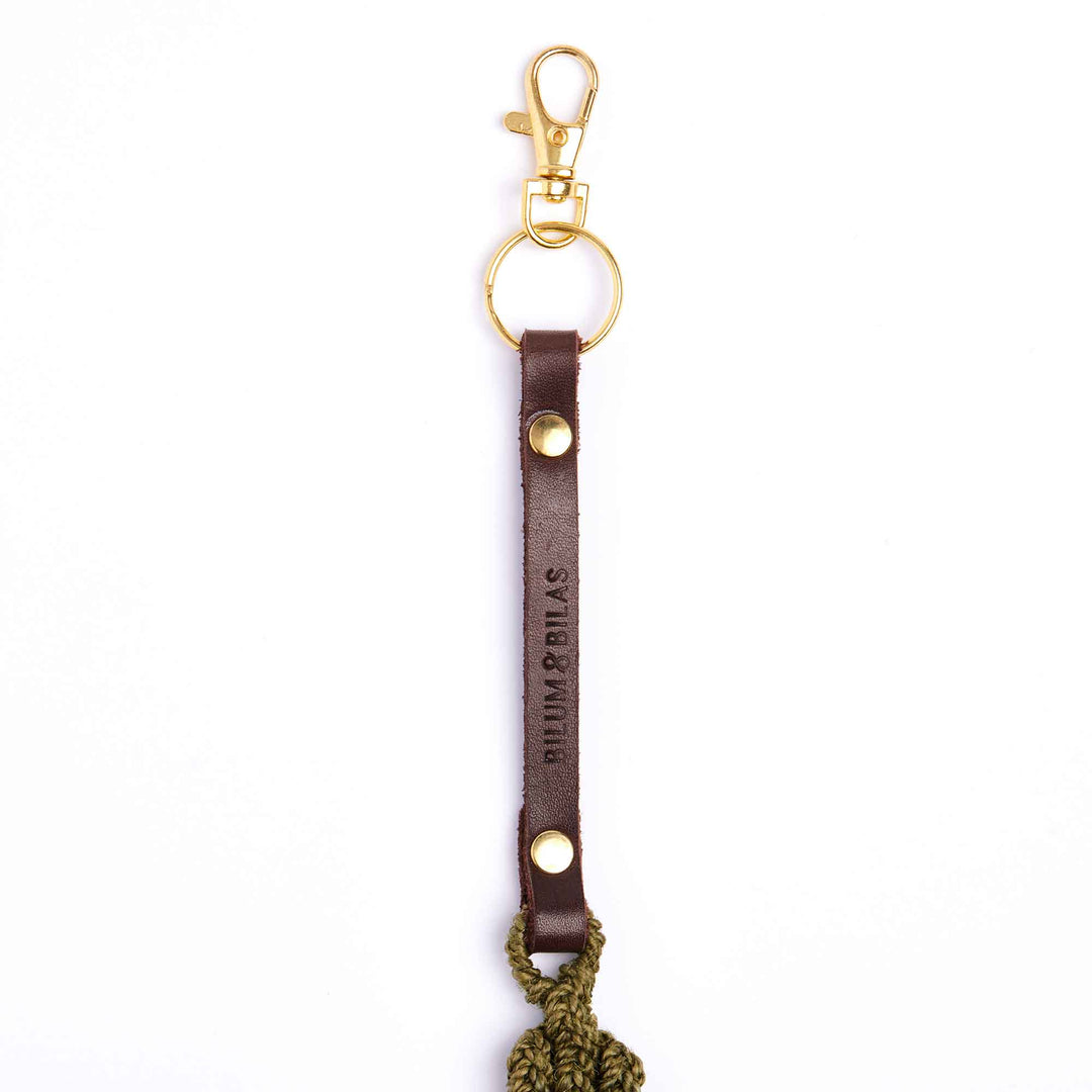 Brown leather keychain with gold clasp and 'Bumarrillas' branding on a white background