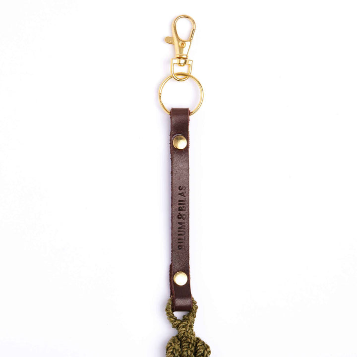 Brown leather keychain with gold clasp and 'Bumarrillas' branding on a white background