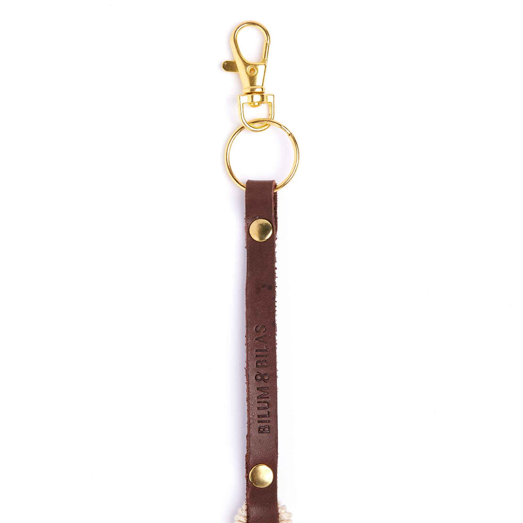 Brown leather keychain with gold hardware on a white background
