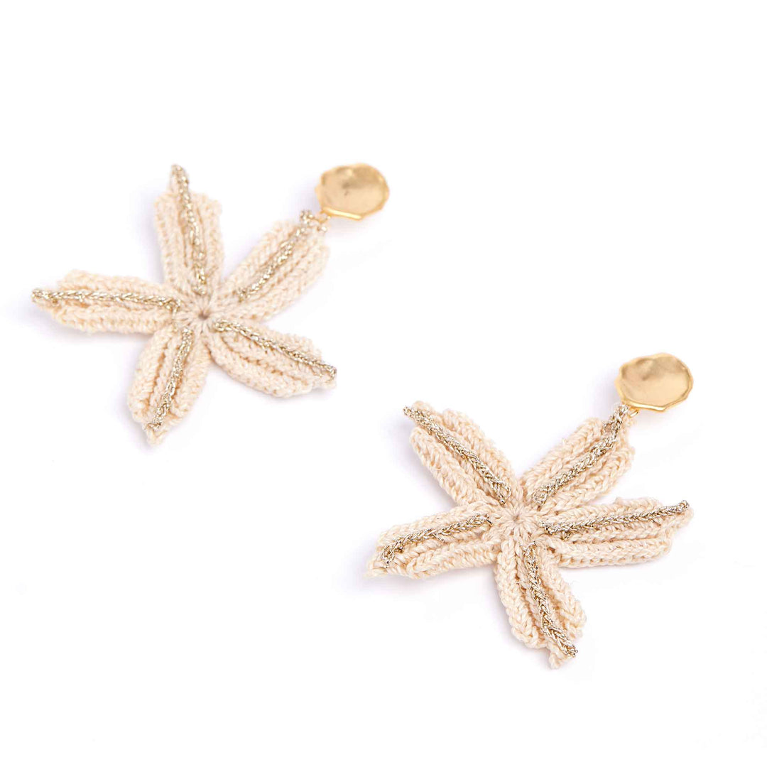 Gold starfish-shaped earrings on a white background