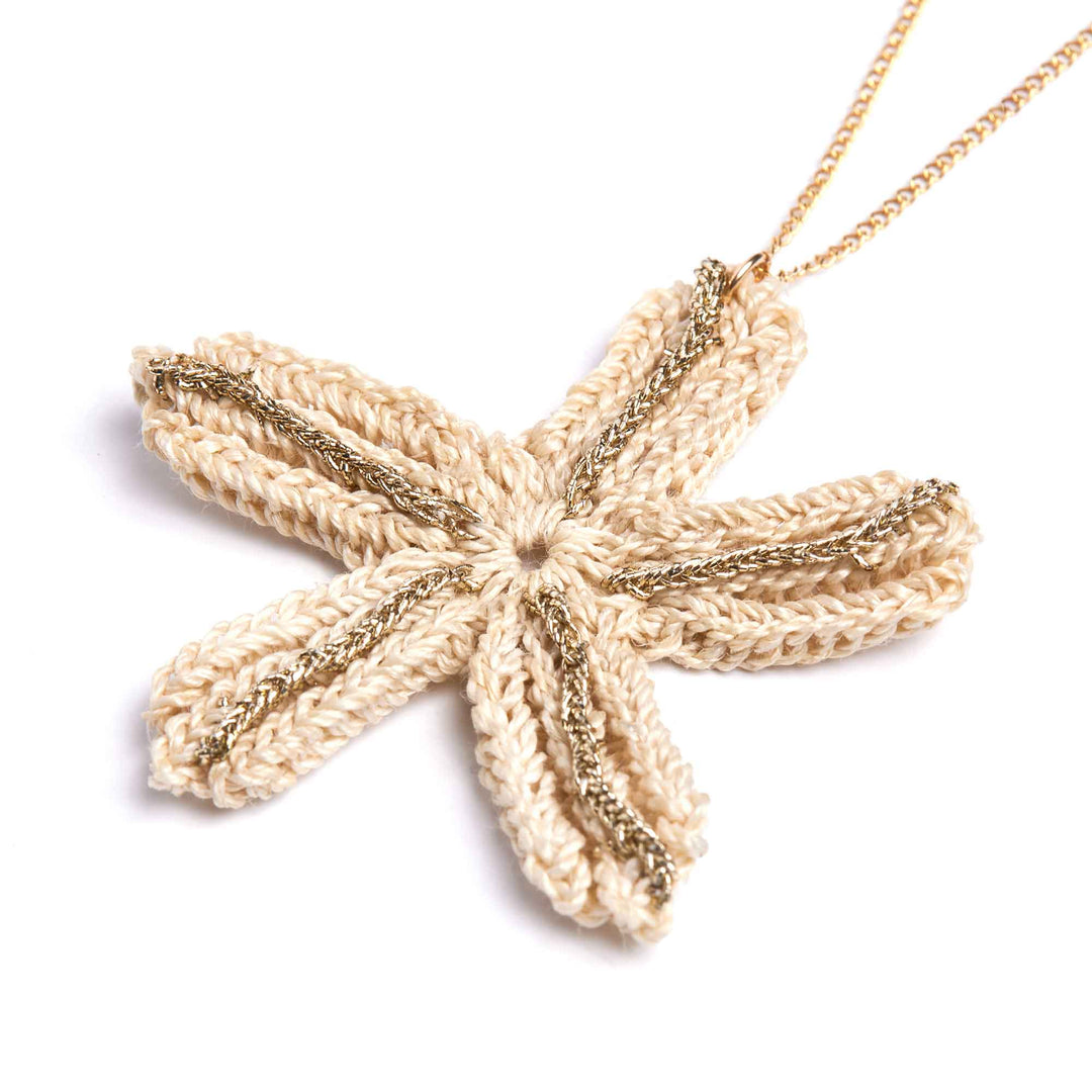 Starfish-shaped pendant on a chain against a white background