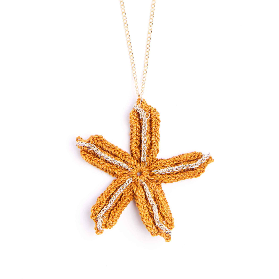 Crocheted starfish pendant on a chain against a white background