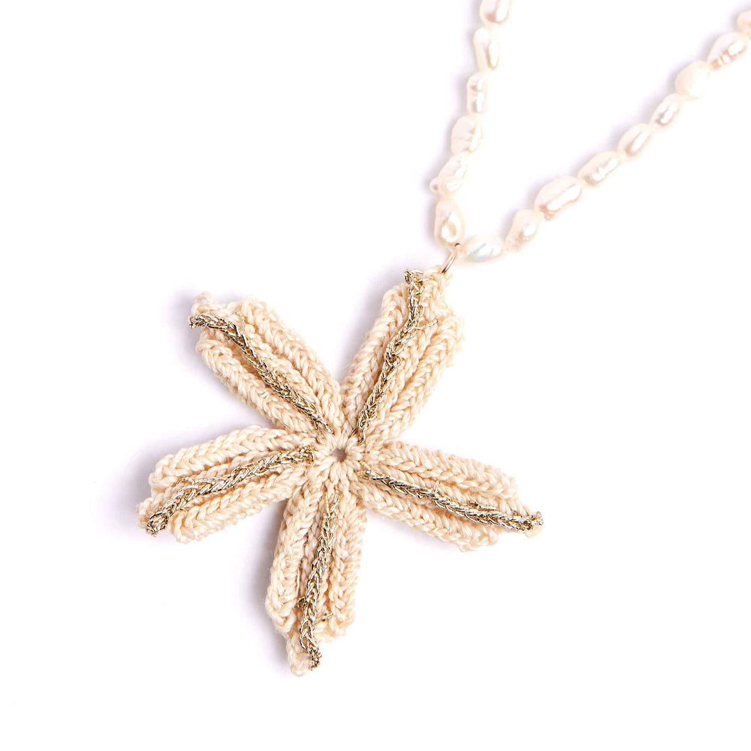 Gold starfish pendant on a chain against a white background