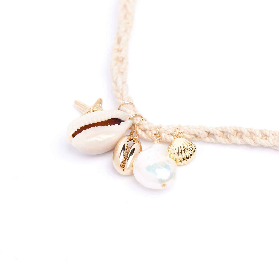 Bracelet with shell and pearl charms on a white background