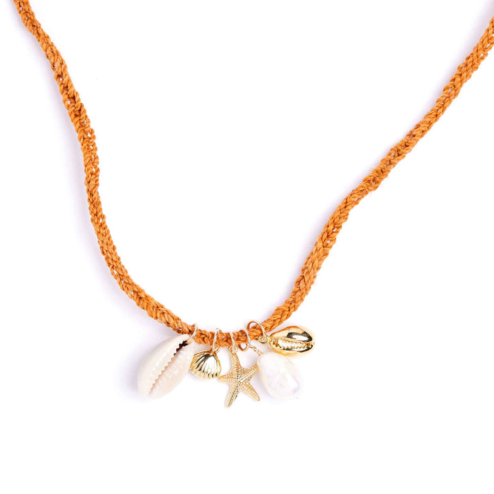 Necklace with shell and starfish charms on an orange cord against a white background