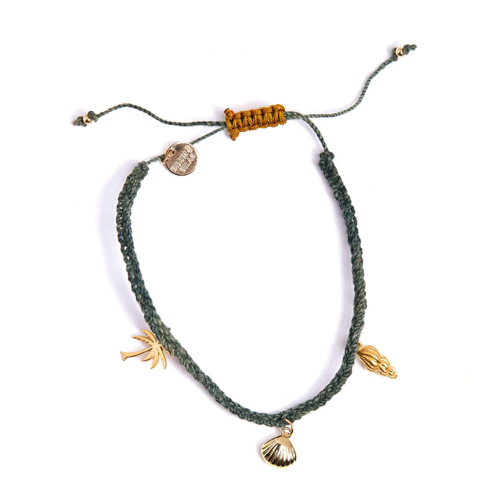 Green braided bracelet with gold charms on a white background