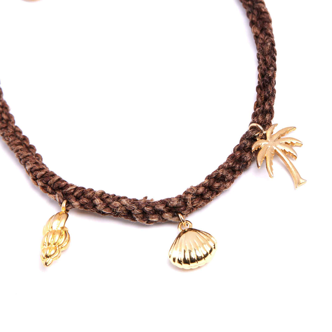 Brown braided necklace with gold shell and leaf-shaped charms on a white background