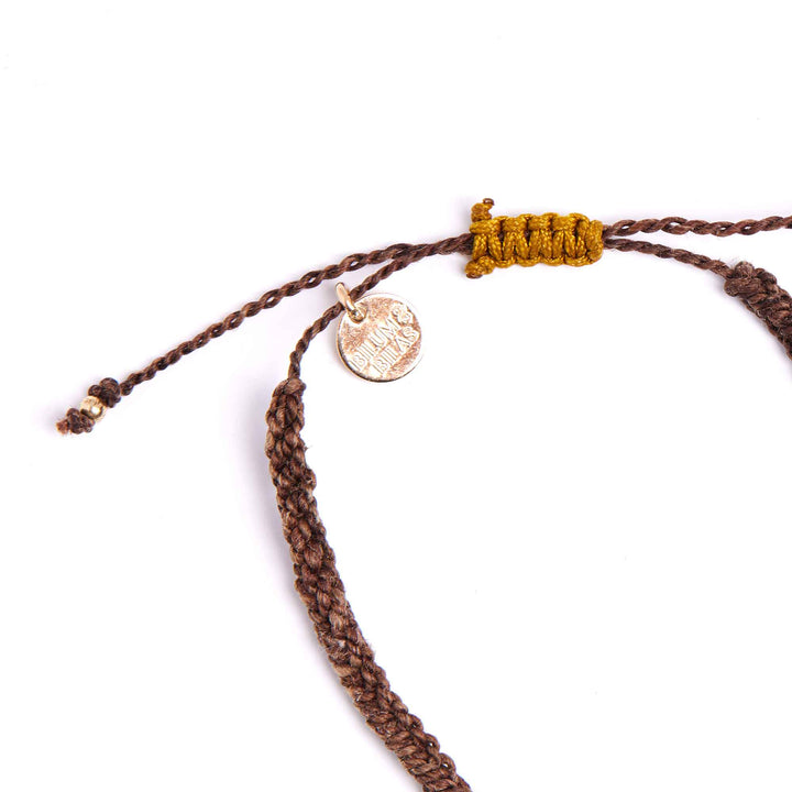 Brown braided bracelet with a gold tag on a white background