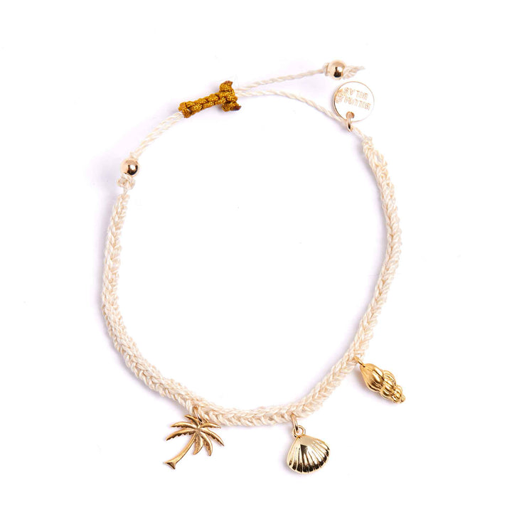 Bracelet with palm tree and shell charms on a white background