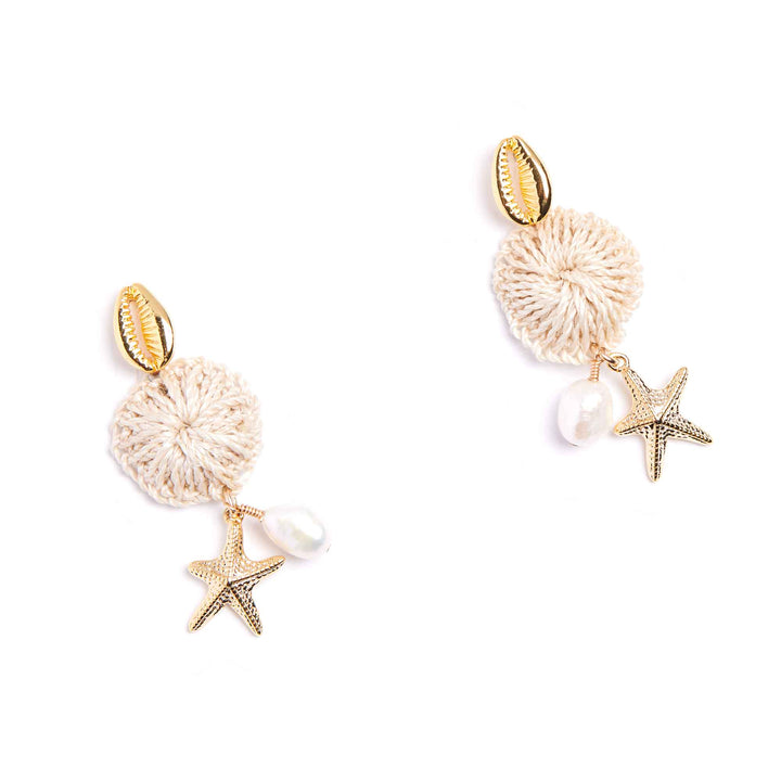 Pair of earrings with shell, starfish, and pearl charms on a white background