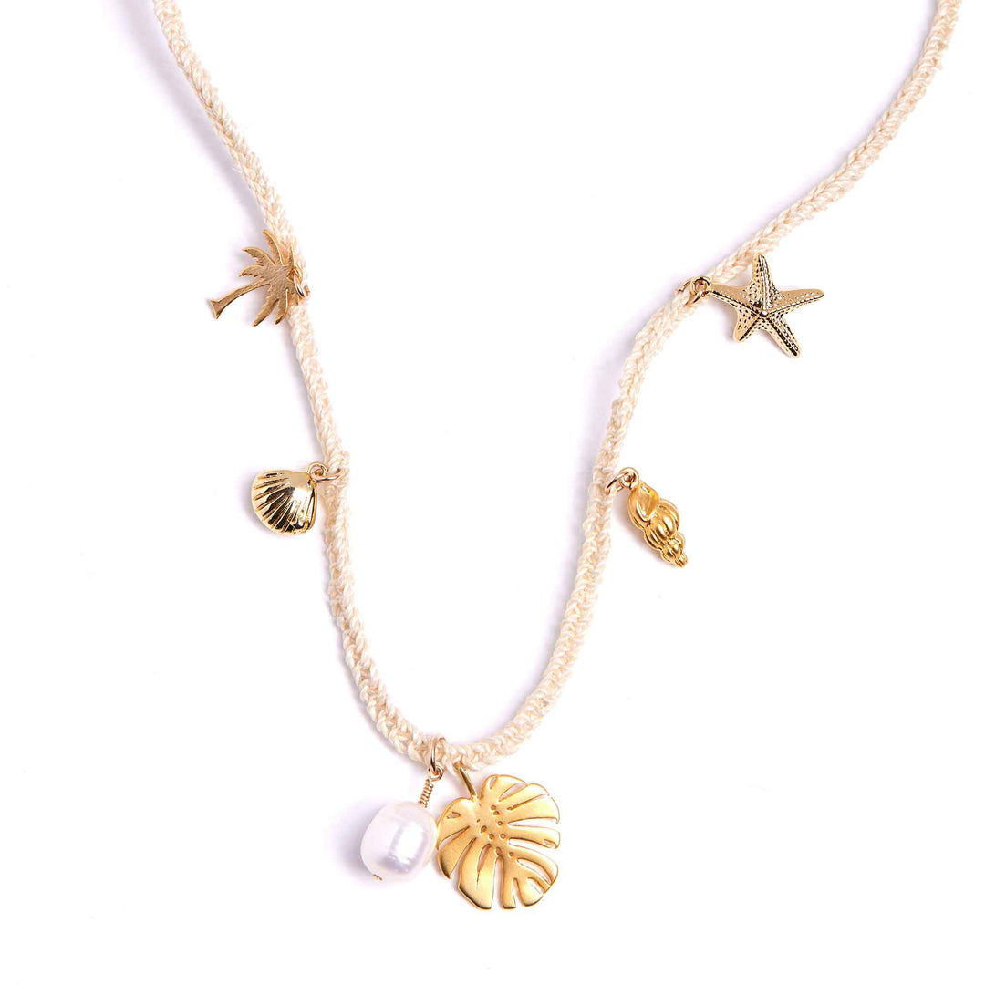 Gold necklace with various sea-themed charms on a white background