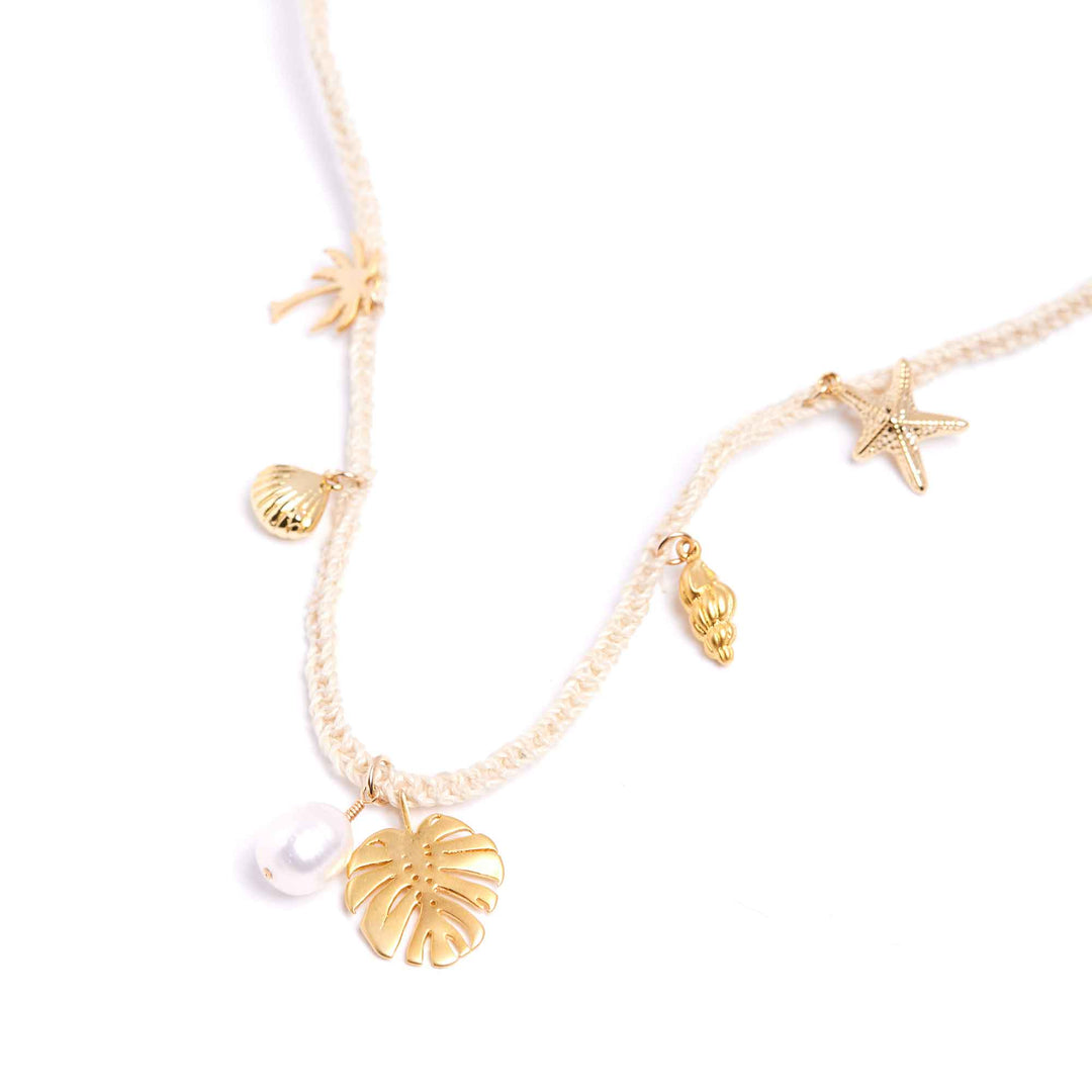 Gold anklets with starfish, shell, and leaf charms on a white background