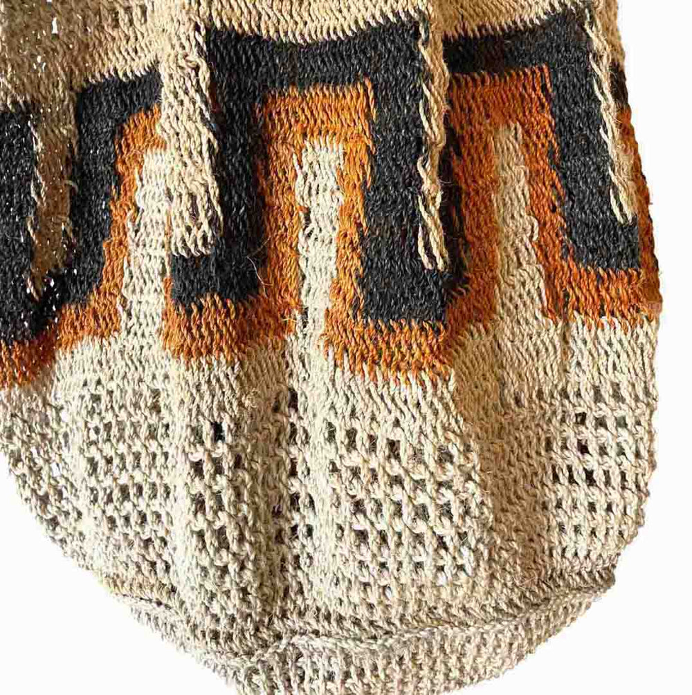 Close up on black and orange line pattern strip bucket bilum with double straps from Papua New Guinea.
